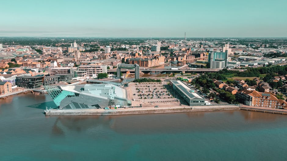 Aerial view of Kingston Riverside showing modern and historic architecture along the River Thames, with a focus on the contemporary building of the Institute of Fishing and the surrounding urban lands